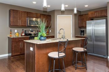 Full kitchen with dark wood cabinets and central island with barstools